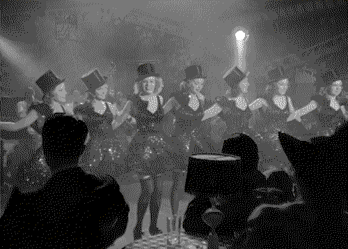 A line of chorus girls on stage in front of an audience of men, from the film Dance Girl Dance.
