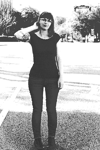 Alexandra standing in the middle of downtown Athens, GA. She is wearing a black top, jeans, black boots, and glasses.
