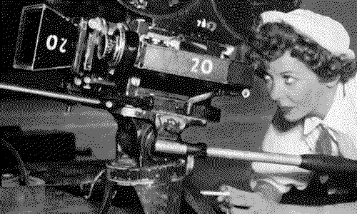 Ida Lupino looking through the viewfinder of a film camera